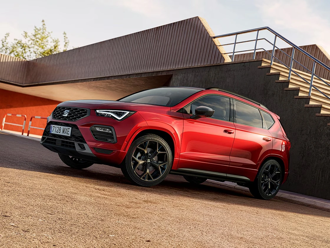 SEAT Ateca rouge devant un escalier urbain, SUV compact dynamique et sobre en carburant