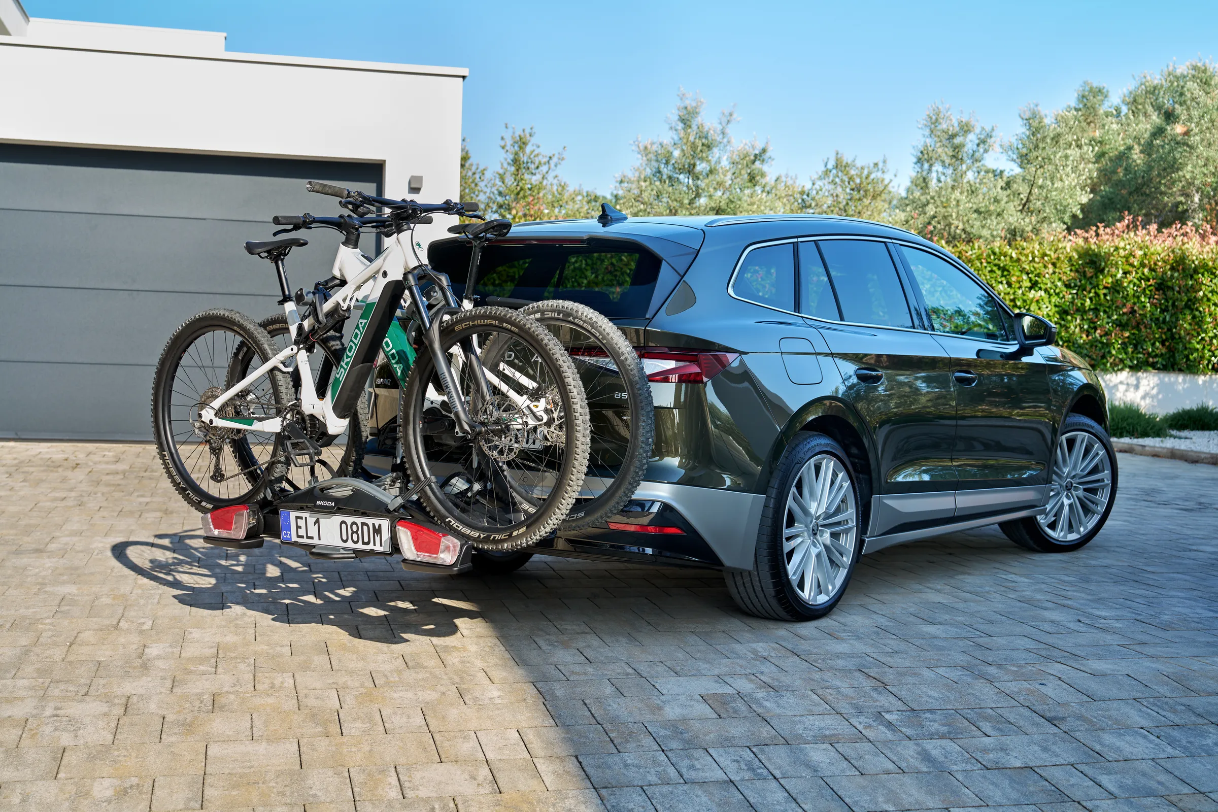 Voiture électrique familiale Škoda équipée d’un porte-vélos sur attelage transportant deux VTT