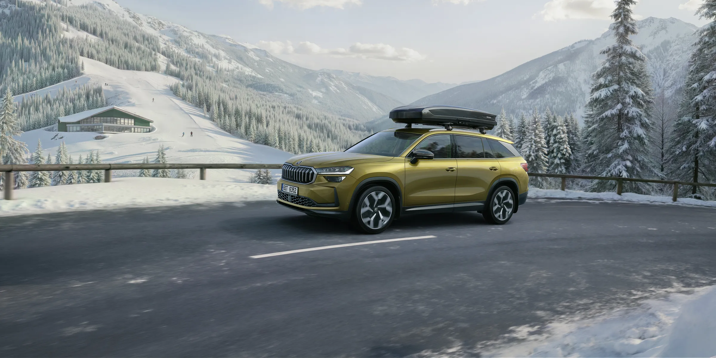 Grand SUV Škoda Kodiaq pour familles nombreuses, chargé pour les sports d’hiver sur route enneigée en montagne
