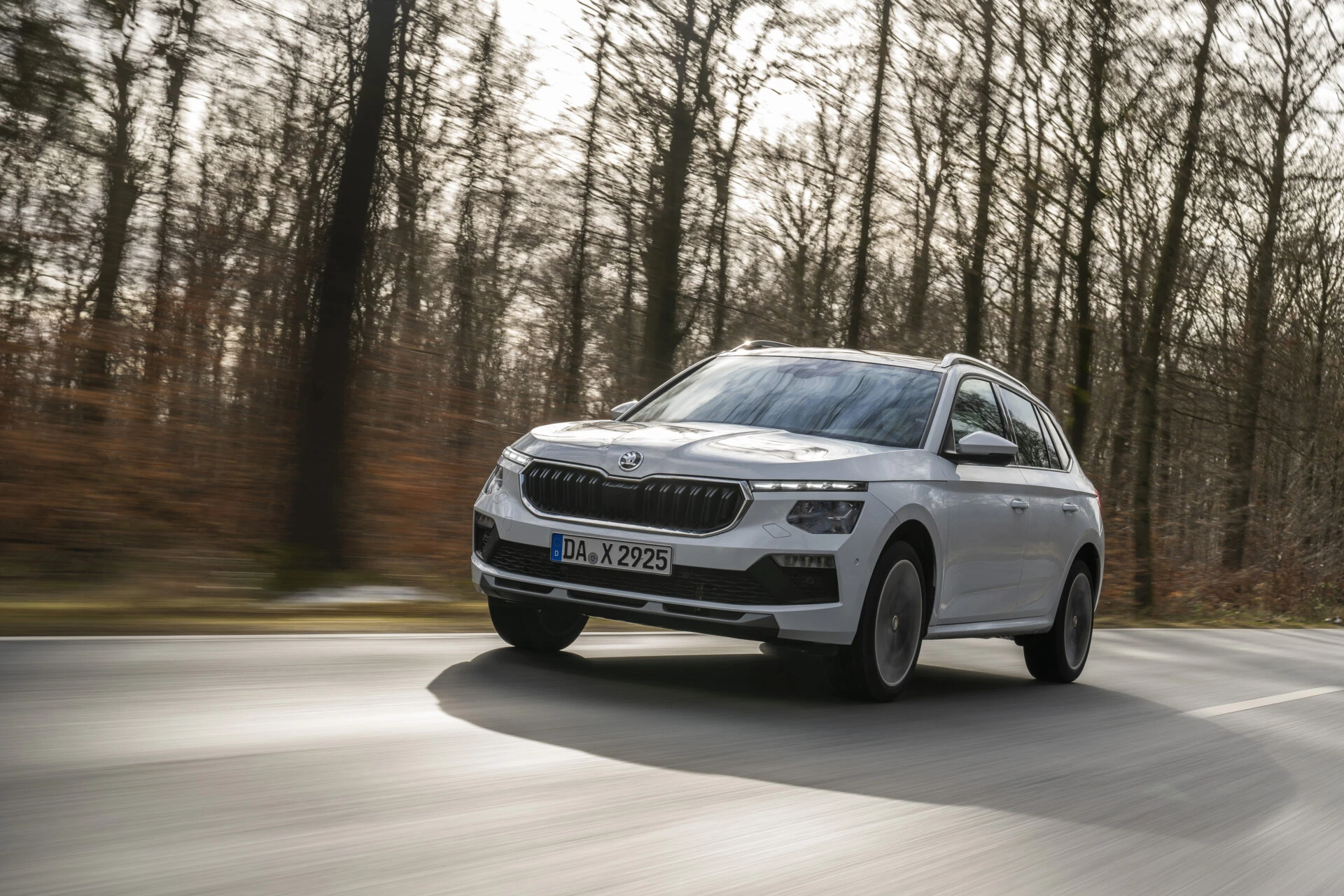Škoda Kamiq, SUV urbain au meilleur rapport qualité-prix, roulant sur route bordée d’arbres