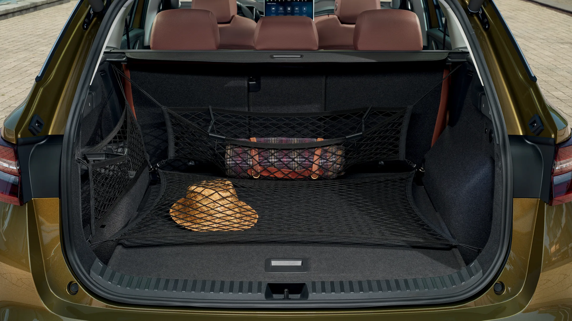 Grand coffre d’un Škoda Kodiaq équipé de filets de rangement Simply Clever, avec chapeau et sac maintenus en place