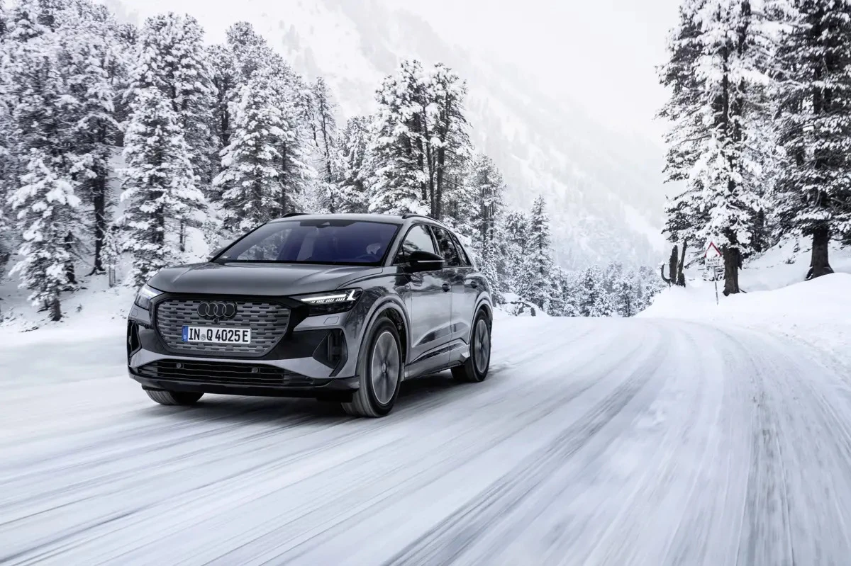 Audi Q4 e-tron électrique circulant sur une route de montagne enneigée