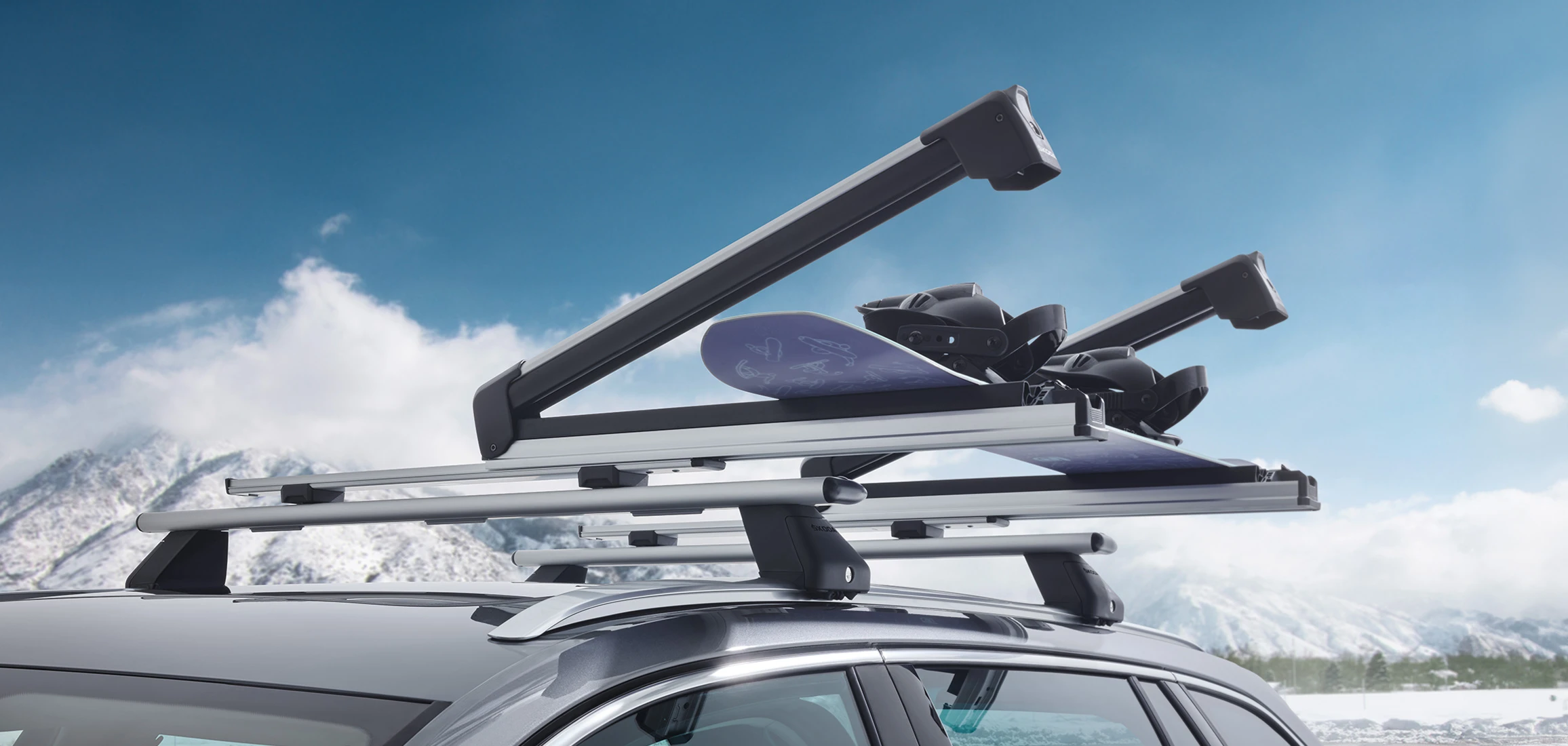 Porte-skis ouvert monté sur les barres de toit d’une voiture avec snowboard