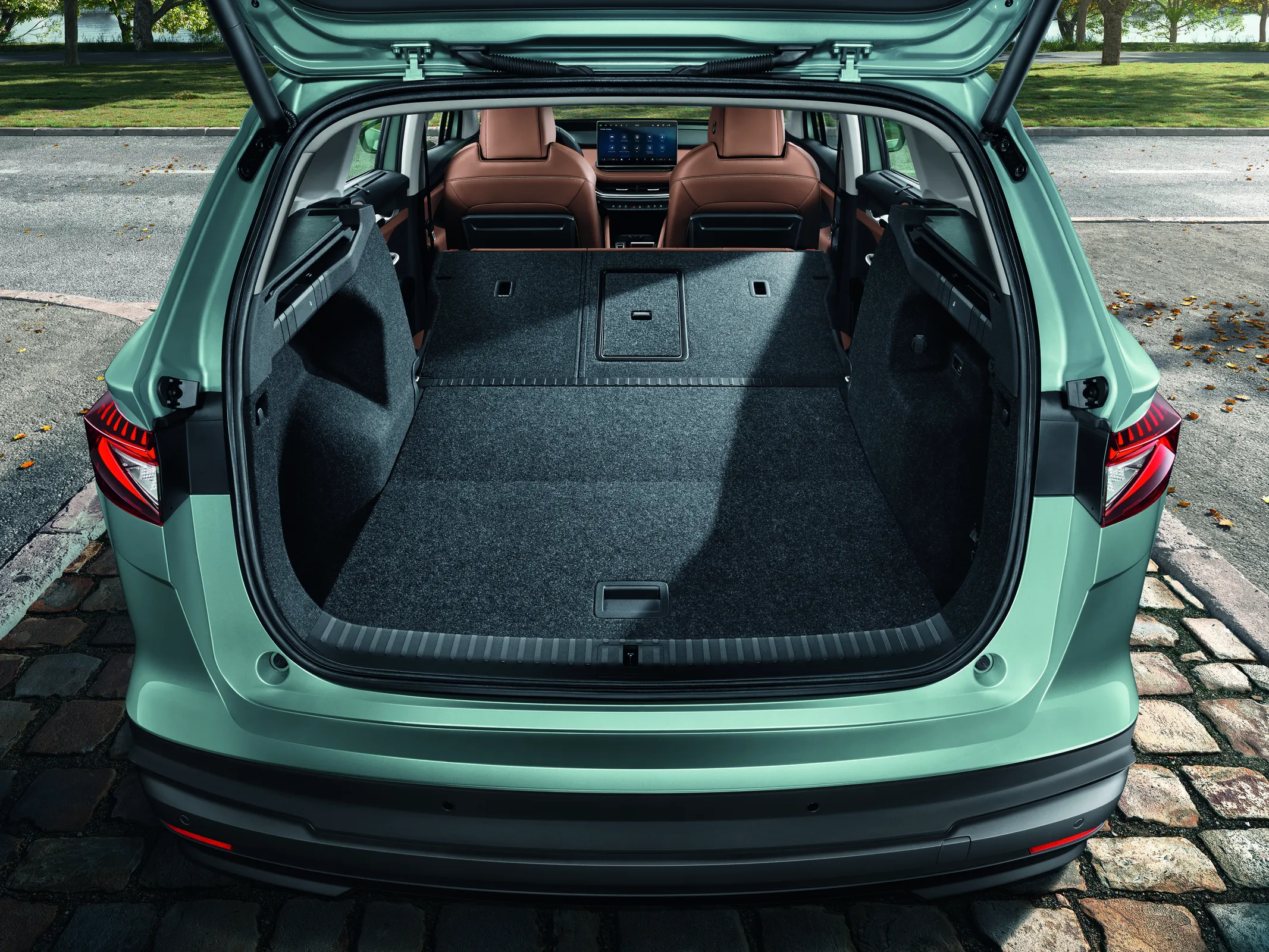 Coffre de SUV électrique ouvert avec sièges rabattus, montrant un volume plat et profond pour les bagages
